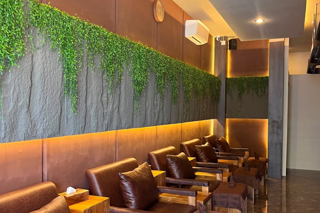 Row of leather reflexology recliners beneath a wall of trailing greenery at Ayu Dewi Spa & Wellness